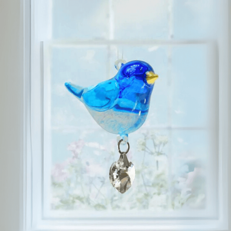 Bluebird crystal suncatcher hanging in a bright window, ready to scatter rainbow light

