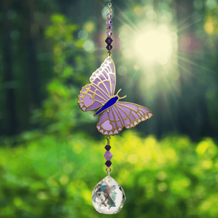 Butterfly Purple Emperor Crystal Suncatcher catching woodland sun – purple butterfly motif, jewel-tone bead cascade and 20 mm prism scattering colour.

