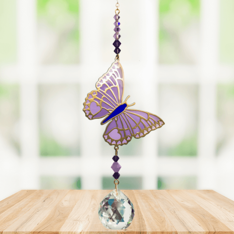 Butterfly Purple Emperor Crystal Suncatcher hanging in a sunny window; lavender-purple enamel wings, faceted violet beads and sparkling crystal ball.
