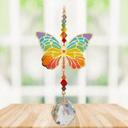 Butterfly Rainbow Crystal Suncatcher hanging in sunny window; rainbow enamel wings, chakra-style beads and sparkling crystal ball.
