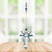 Blue zircon cascade guardian angel crystal suncatcher hanging in a bright window
