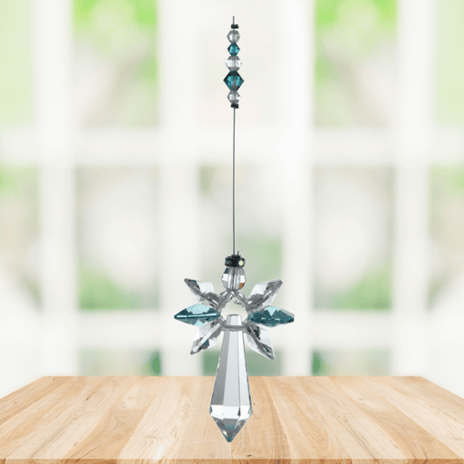 Blue zircon cascade guardian angel crystal suncatcher hanging in a bright window
