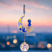 Cats on Roof – Moonlight Crystal Suncatcher at dusk; blue enamel cats on golden chimney, indigo bead cascade and 20 mm prism scattering rainbow light over city bokeh.

