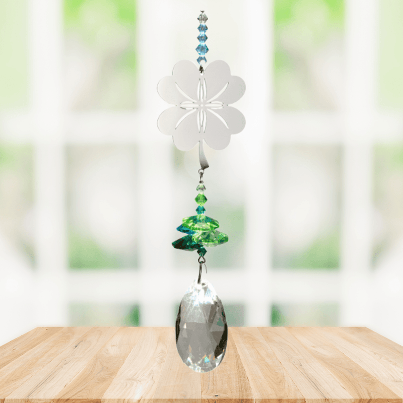 Wild Things Crystal Fantasy Four Leaf Clover suncatcher hanging by a window with green and blue crystals