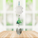 Wild Things Crystal Fantasy Four Leaf Clover suncatcher hanging by a window with green and blue crystals