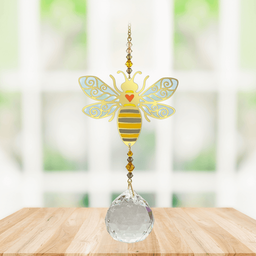 Wild Things Crystal Wonders bee autumn gold crystal suncatcher hanging in a bright window, mirror-gold bee motif and 30mm crystal ball pendant.