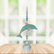 Dolphin Marine Crystal Suncatcher hanging in a sunny window; sea-green enamel dolphin, faceted blue beads and sparkling crystal ball.
