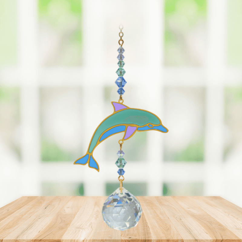 Dolphin Marine Crystal Suncatcher hanging in a sunny window; sea-green enamel dolphin, faceted blue beads and sparkling crystal ball.
