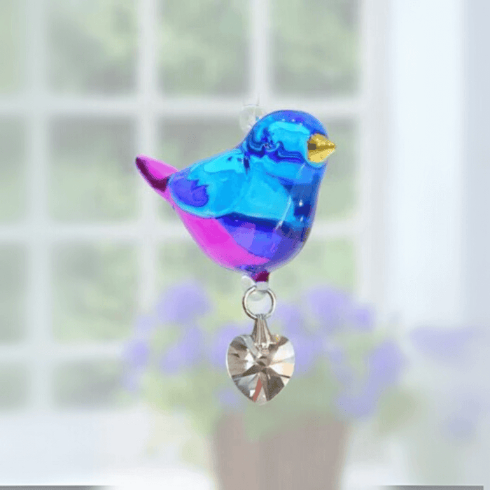 Handmade blue-and-violet Evening Song crystal suncatcher shining before soft blooms

