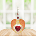 Gold angel wing heart suncatcher with garnet red crystal heart hanging in a bright window
