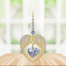 Gold angel wing heart suncatcher with light amethyst crystal heart hanging in a bright window
