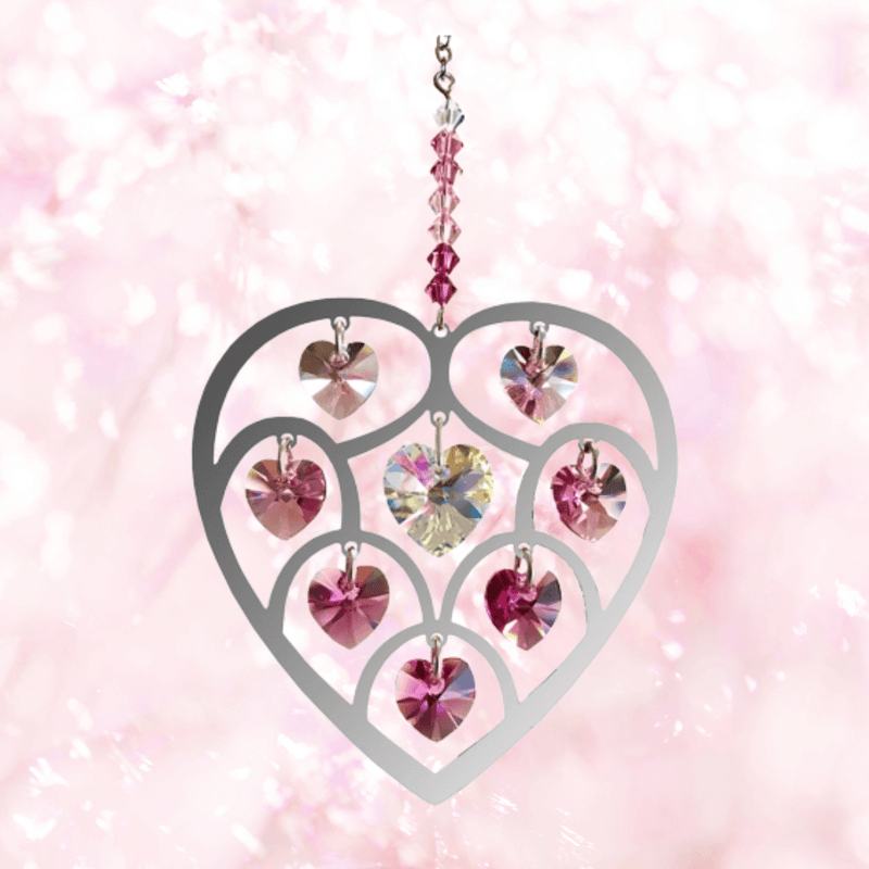 Heart of Hearts deep-rose suncatcher sparkling against a dreamy pink backdrop, ready to cast rainbows

