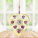Handmade gold Heart of Hearts deep-rose crystal suncatcher displayed on a wooden table before a bright window


