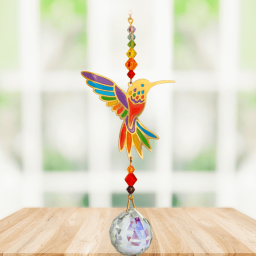 Hummingbird Rainbow Crystal Suncatcher hanging in bright window; rainbow enamel wings, chakra-style beads and sparkling crystal ball.
