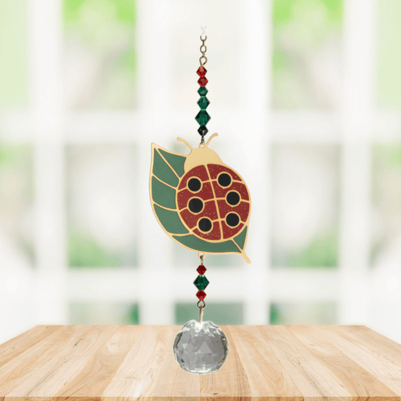 Wild Things Ladybug on Leaf multicolour crystal suncatcher hanging in a window with red and green crystal beads and clear prism
