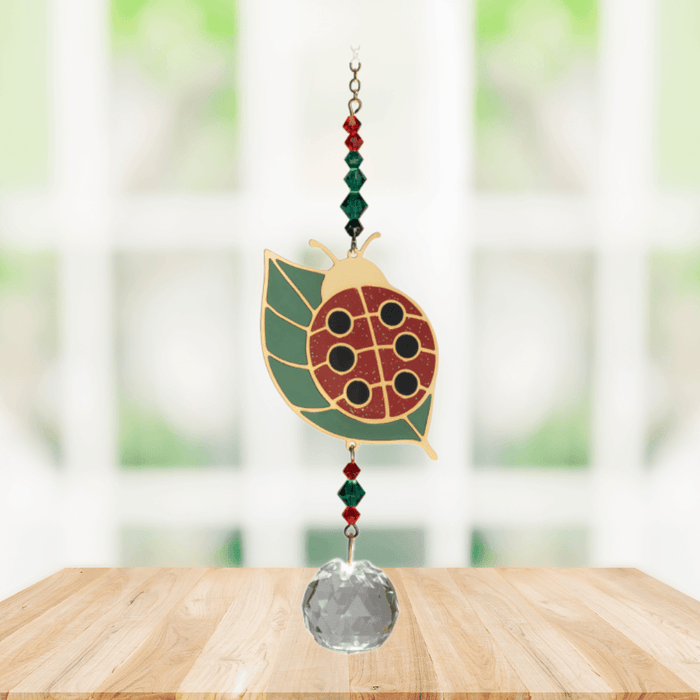 Wild Things Ladybug on Leaf multicolour crystal suncatcher hanging in a window with red and green crystal beads and clear prism
