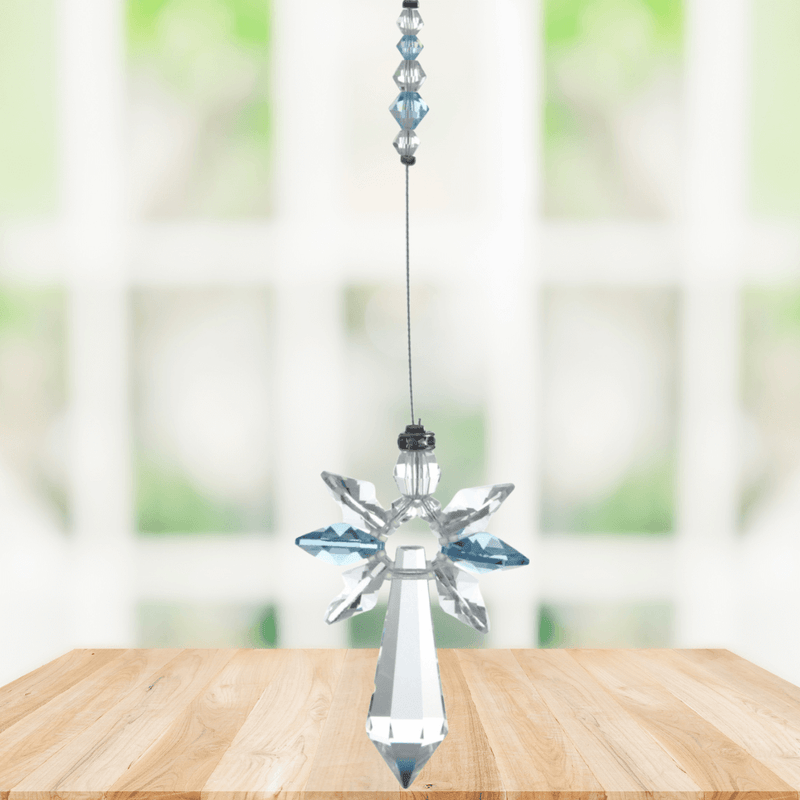 Large aquamarine guardian angel crystal suncatcher hanging in a bright window