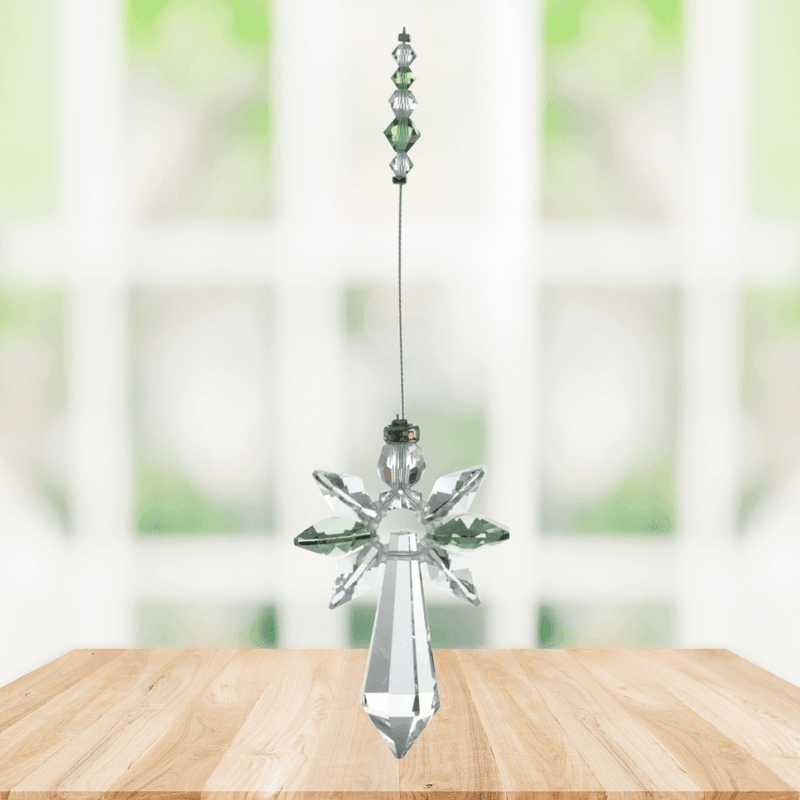 Large peridot guardian angel crystal suncatcher hanging in a bright window

