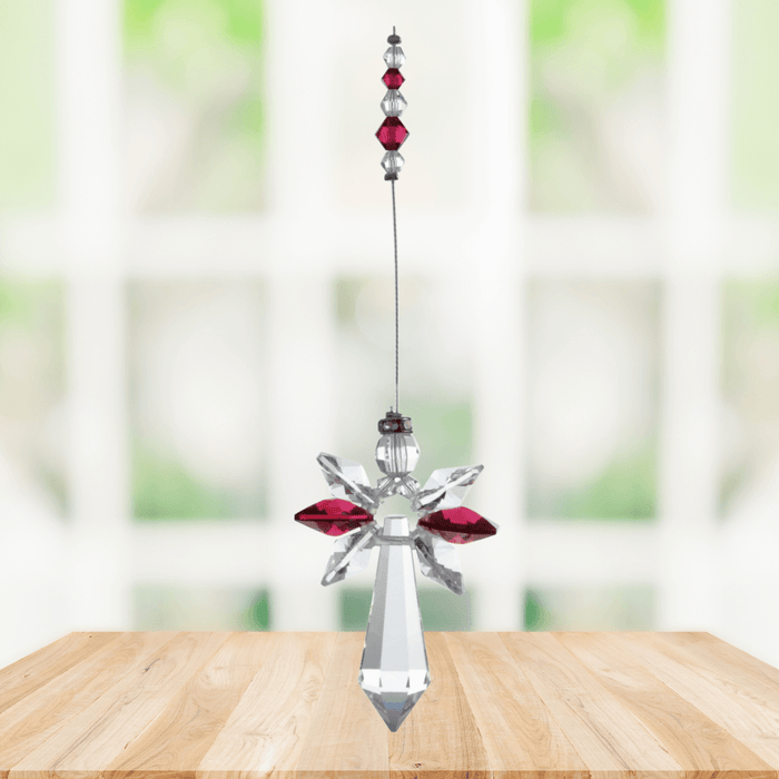 Large ruby guardian angel crystal suncatcher hanging in a bright window
