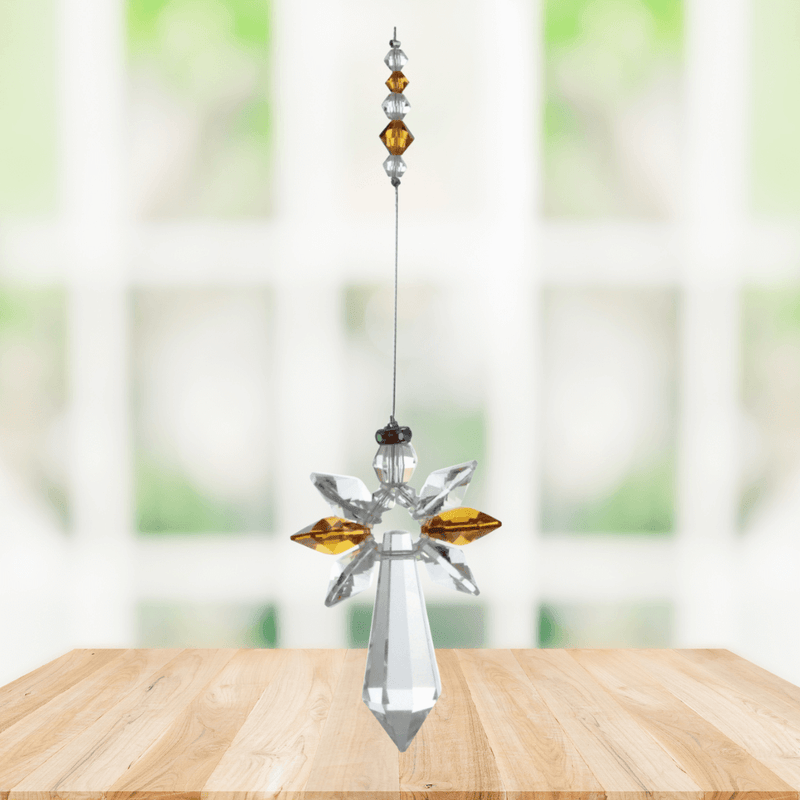 Large topaz guardian angel crystal suncatcher hanging in a bright window