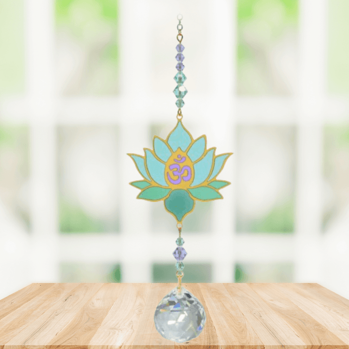 Lotus Aurora Crystal Suncatcher hanging in a sunny window; aqua-mint lotus motif, lavender-teal beads and sparkling crystal ball.
