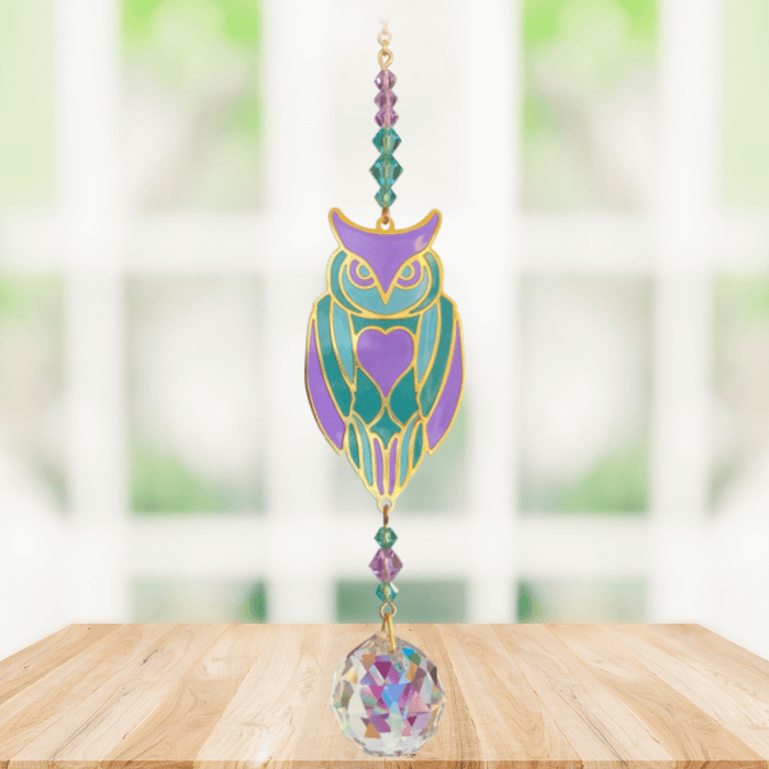 Owl Aurora Crystal Suncatcher hanging in a bright window; pastel owl motif, amethyst-emerald beads and sparkling crystal ball.
