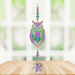 Owl Aurora Crystal Suncatcher hanging in a bright window; pastel owl motif, amethyst-emerald beads and sparkling crystal ball.
