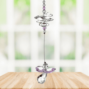 Rose pink guardian angel crystal cascade suncatcher hanging in a bright window