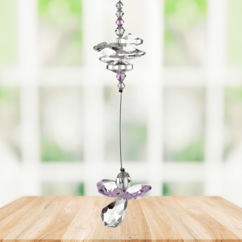 Rose pink guardian angel crystal cascade suncatcher hanging in a bright window