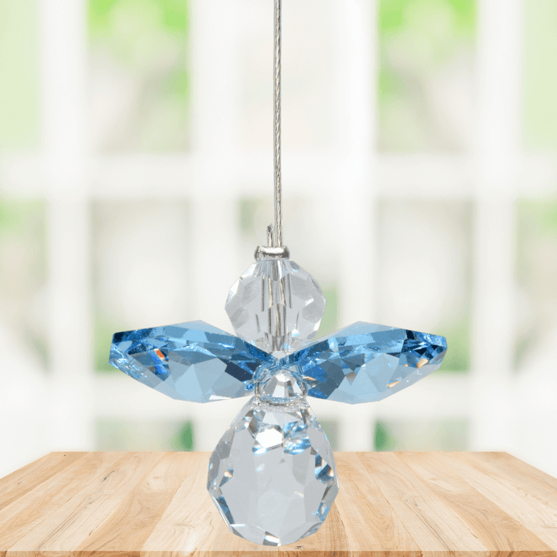 Small aquamarine guardian angel crystal suncatcher sparkling in a bright window