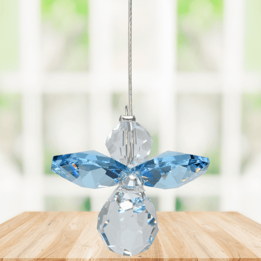 Small aquamarine guardian angel crystal suncatcher sparkling in a bright window
