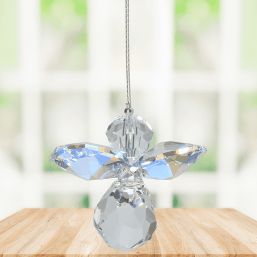Small aurora borealis guardian angel crystal suncatcher sparkling in a bright window
