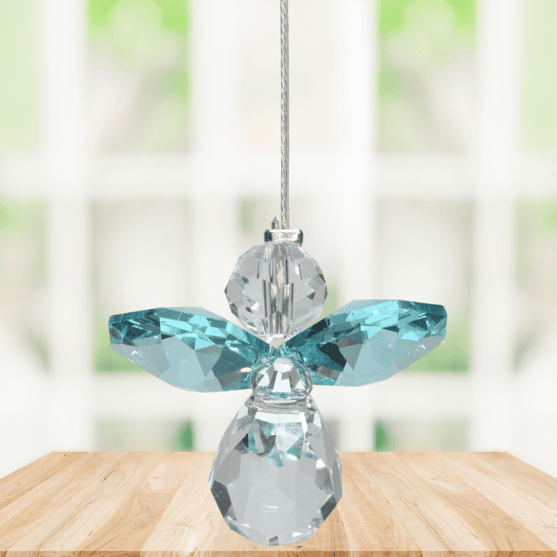 Small blue zircon guardian angel Swarovski crystal suncatcher sparkling in a bright window