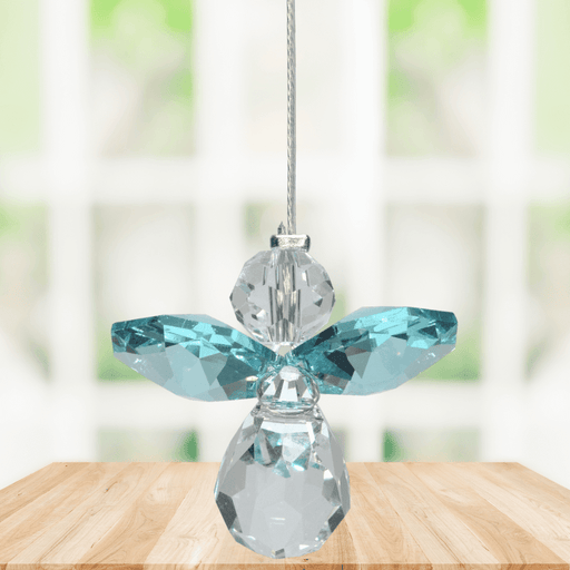 Small blue zircon guardian angel Swarovski crystal suncatcher sparkling in a bright window
