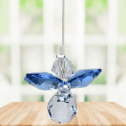 Small sapphire guardian angel crystal suncatcher sparkling in a bright window