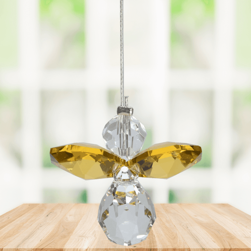 Small topaz guardian angel crystal suncatcher sparkling in a bright window