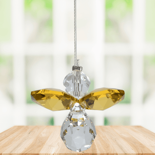 Small topaz guardian angel crystal suncatcher sparkling in a bright window