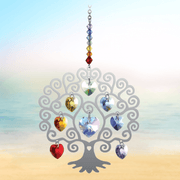 Tree of Life Chakra crystal suncatcher sparkling against a calm seaside horizon

