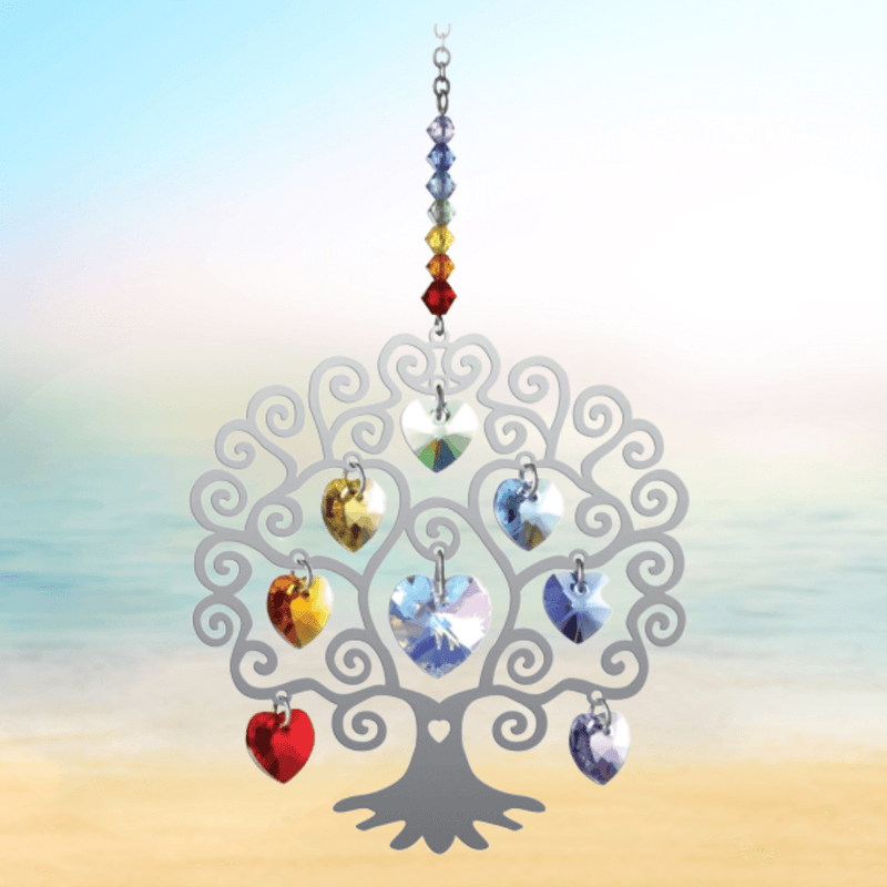 Tree of Life Chakra crystal suncatcher sparkling against a calm seaside horizon

