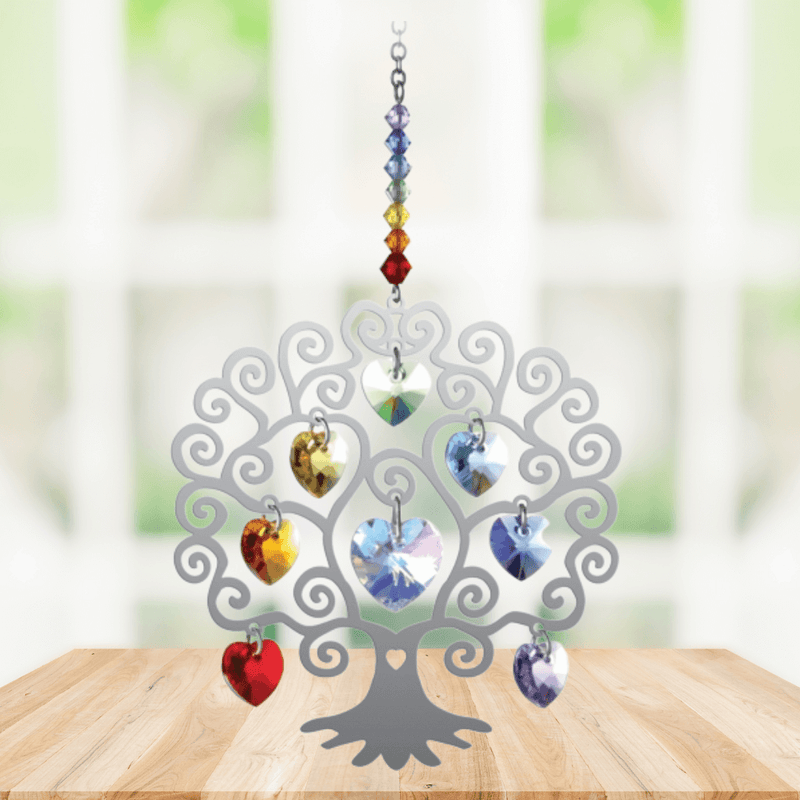 Tree of Life Chakra suncatcher with rainbow crystal hearts displayed on a wooden table

