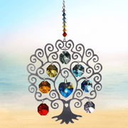Large Tree of Life Chakra crystal suncatcher sparkling against a calm seaside horizon

