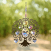 Tree of Life summer crystal suncatcher sparkling in sunlight against a leafy woodland path

