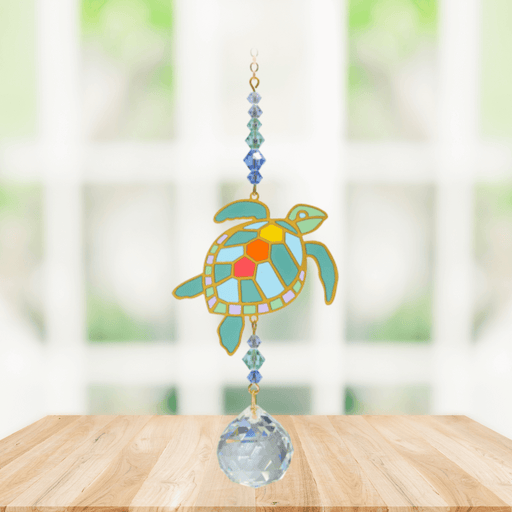Turtle Marine Crystal Suncatcher hanging in bright window; turquoise enamel turtle, sea-blue beads and sparkling crystal ball.
