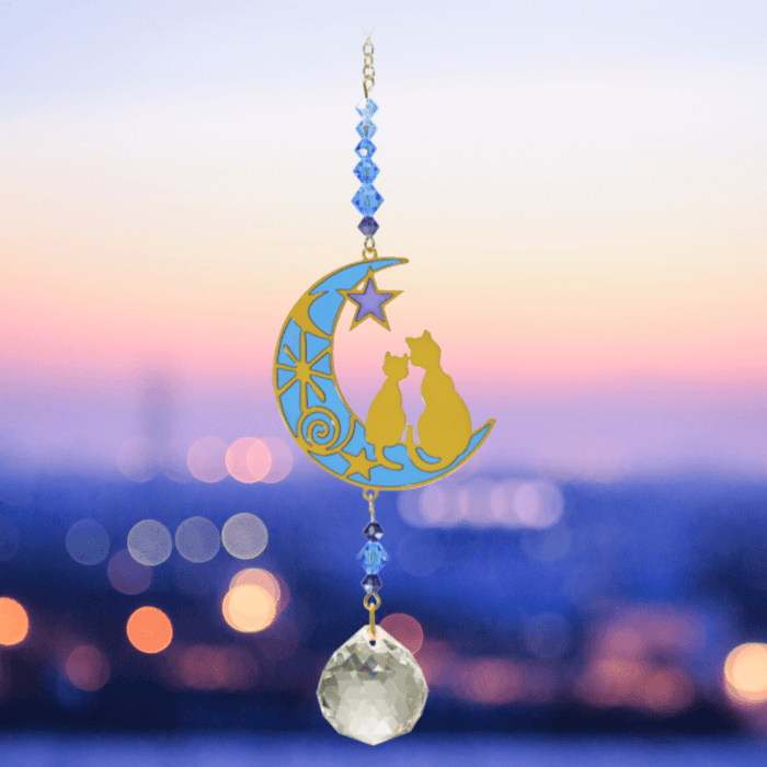 Two Cats Moonlight Crystal Suncatcher against twilight skyline – crescent moon cats, indigo bead cascade and 20 mm prism scattering rainbow light.

