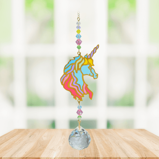 Unicorn Confetti Crystal Suncatcher hanging in a sunny window; colourful unicorn silhouette, candy-hued beads and sparkling crystal ball.
