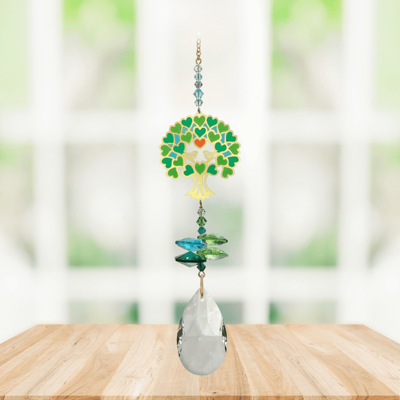 Tree of Life green Window Jewels crystal suncatcher hanging in a bright window, mirror-gold motif with green crystals and clear drop.