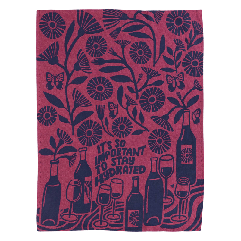 Flat lay Funny tea towel with wine bottles, glasses, and the phrase “It’s so important to stay hydrated”

