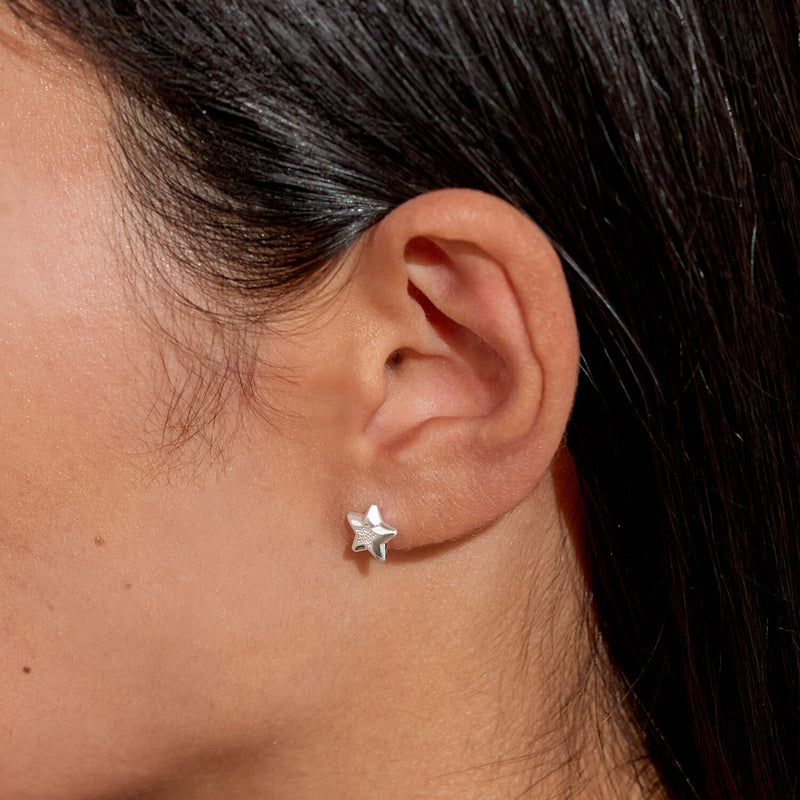 “Lifestyle image – silver star stud earring worn in lobe”
