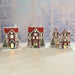 Lifestyle scene of matching wooden LED Christmas houses glowing on a tabletop.