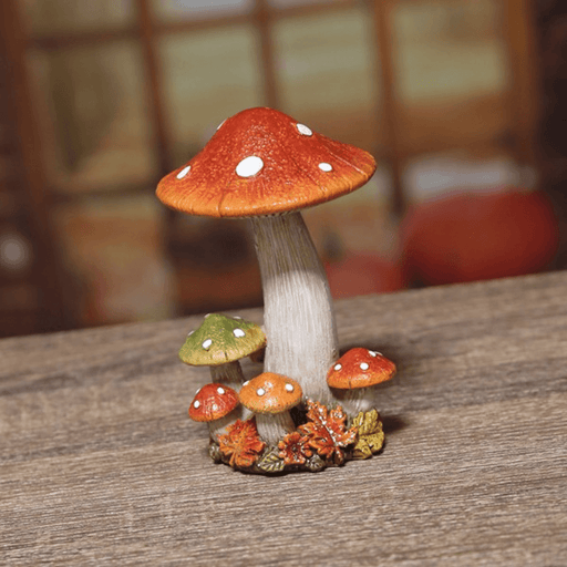 Lifestyle photo of a small autumn toadstool ornament on a wooden surface with a blurred rustic backdrop.